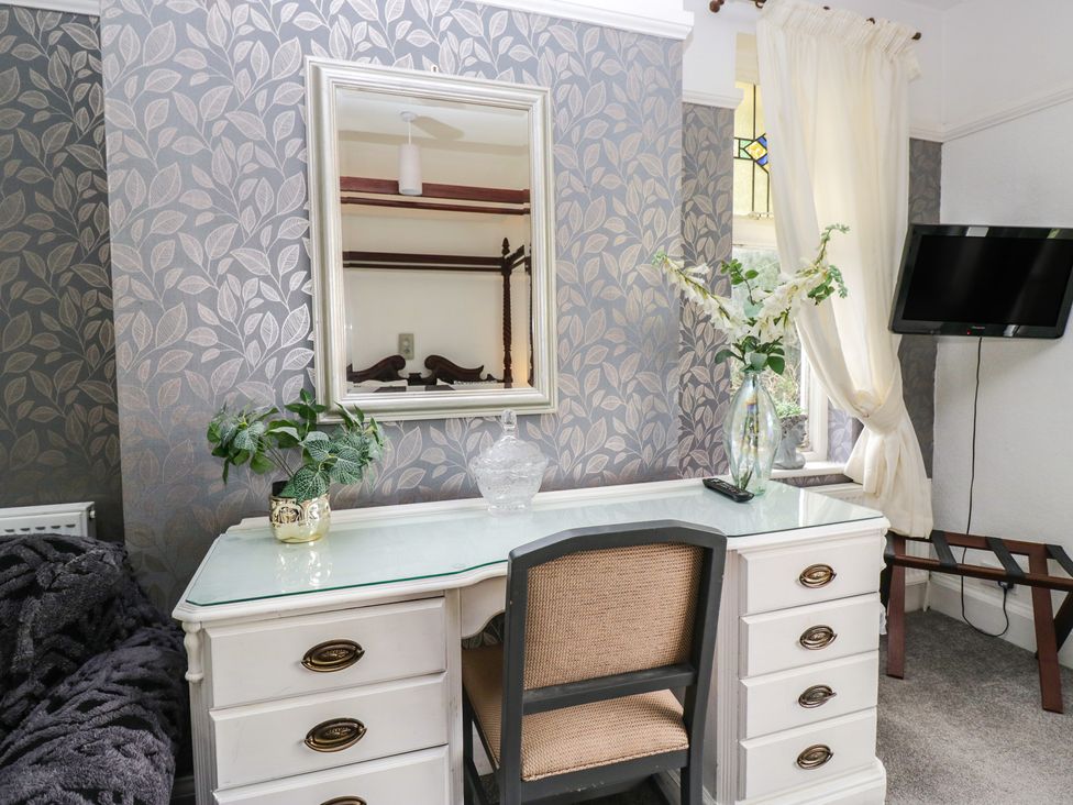 A bedroom with a desk and mirror at Herdwick Croft in Bassenthwaite