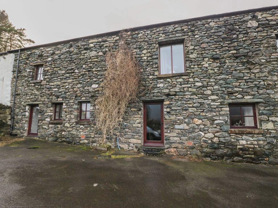 A stone building with windows and a front door at Newlands Cottage in Keswick