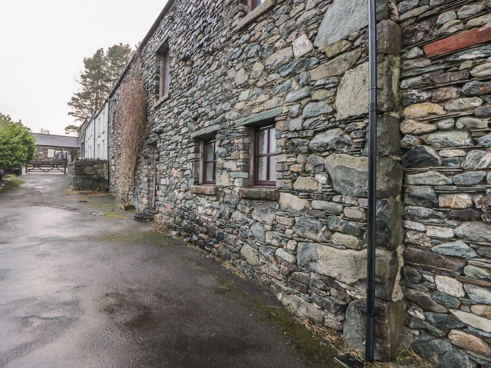 A stone building with windows and a pathway at Newlands Cottage in Keswick