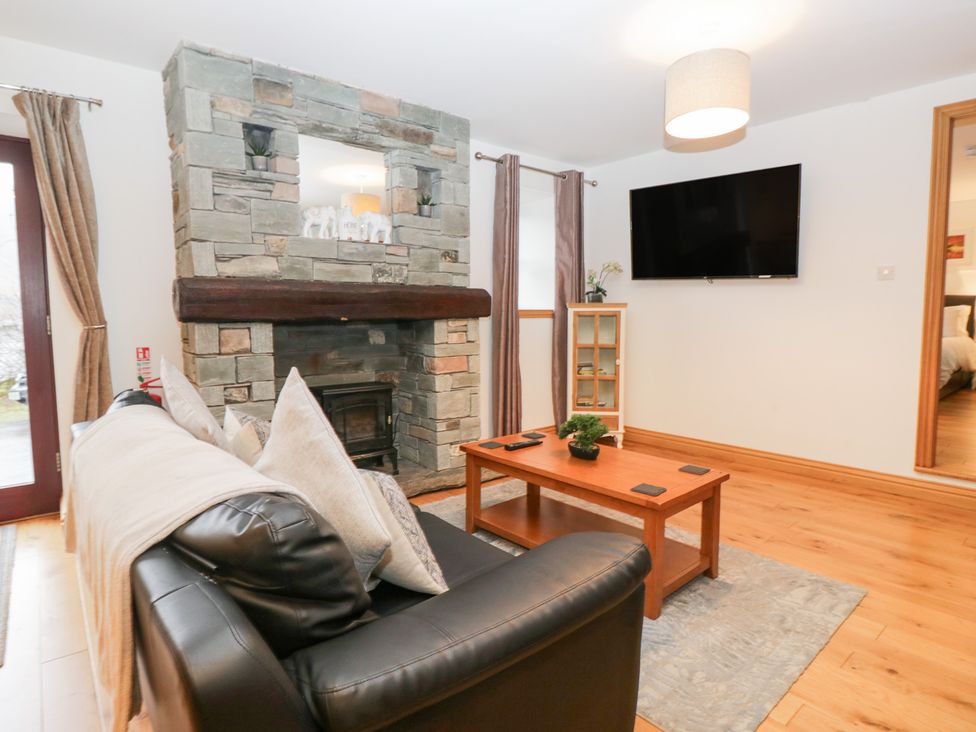 A living room with a fireplace and sofa at Newlands Cottage in Keswick