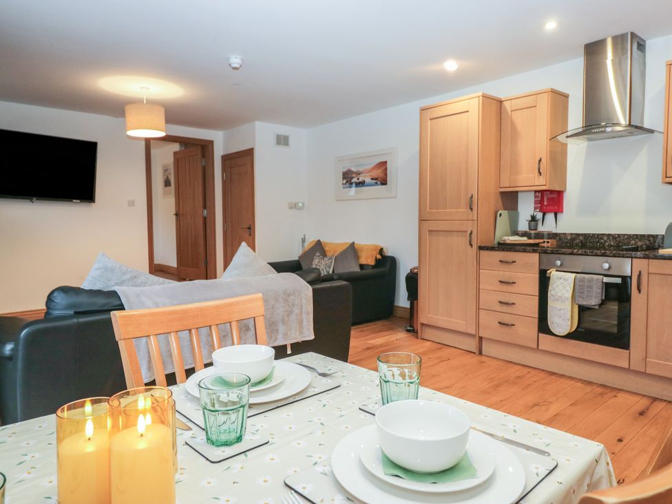 A living room with a kitchen area and dining table at Newlands Cottage Keswick