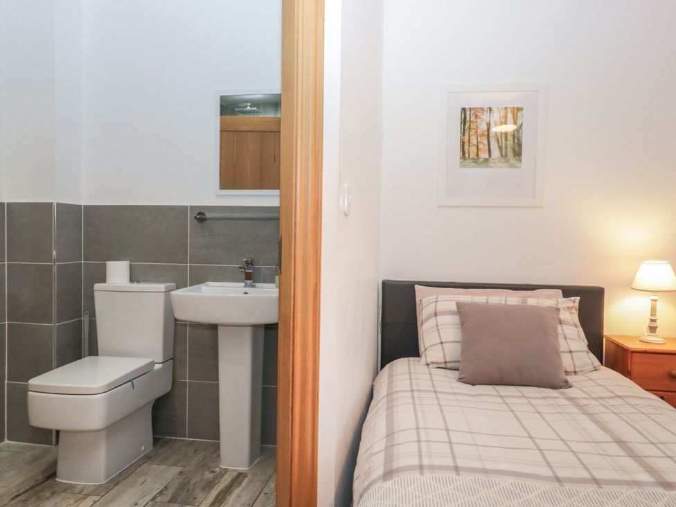 A bedroom with an attached bathroom at Newlands Cottage in Keswick