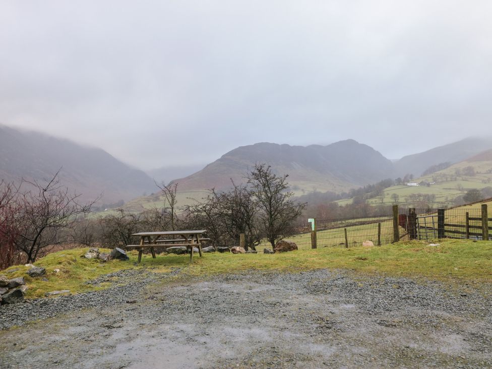 An outdoor area with a picnic table and mountains at Newlands Cottage in Keswick