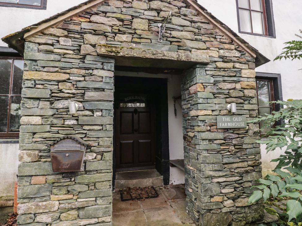 An entrance with a stone wall and door at Birkbank Farm in Cockermouth