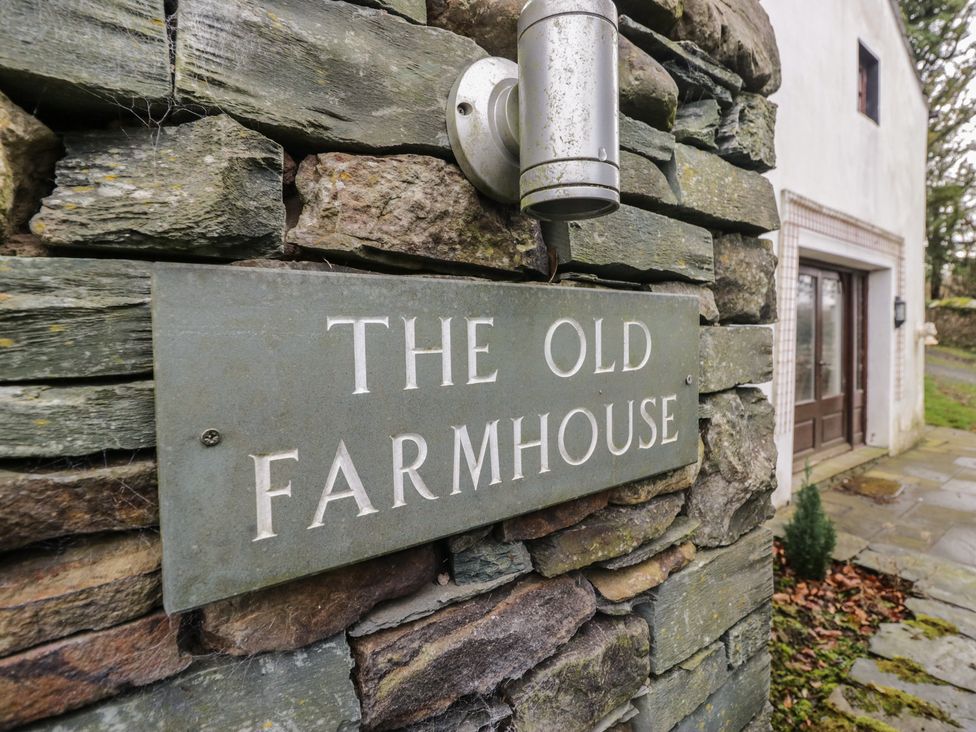 A sign on a stone wall at The Old Farmhouse in Cockermouth