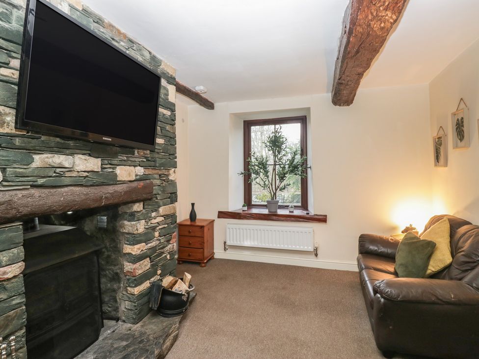 A living room with a television and a fireplace at Birkbank Farm Cockermouth