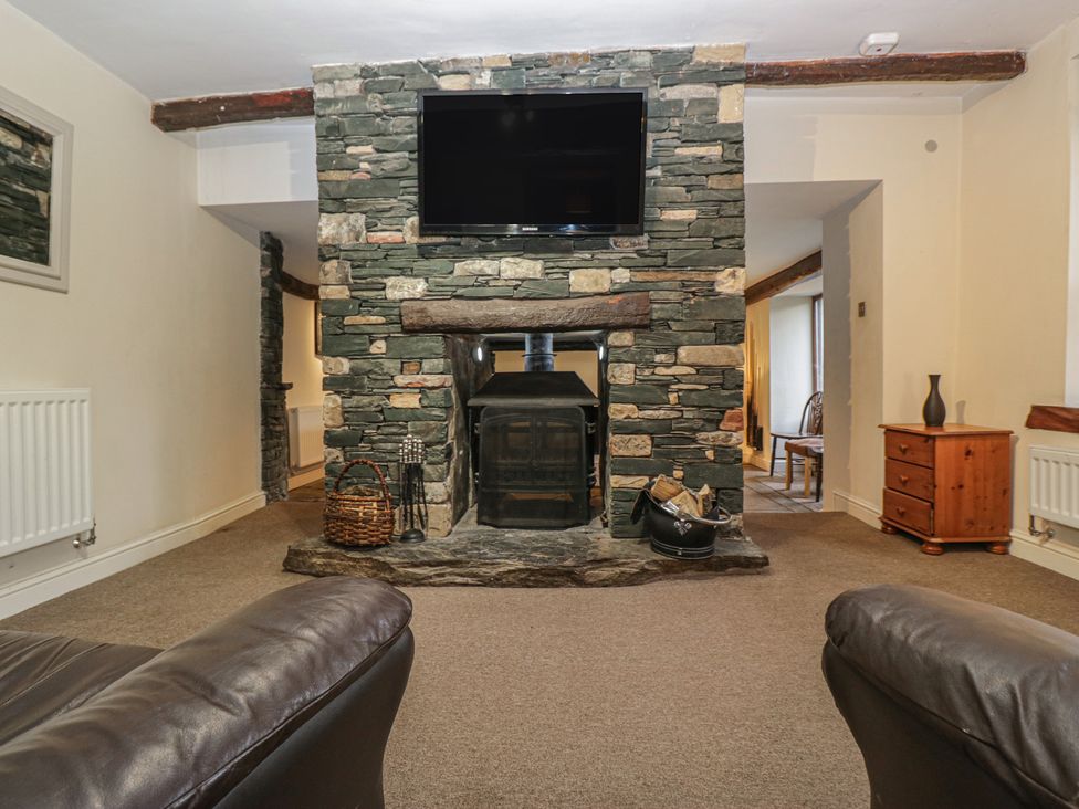 A living room with a fireplace and television at Birkbank Farm in Cockermouth