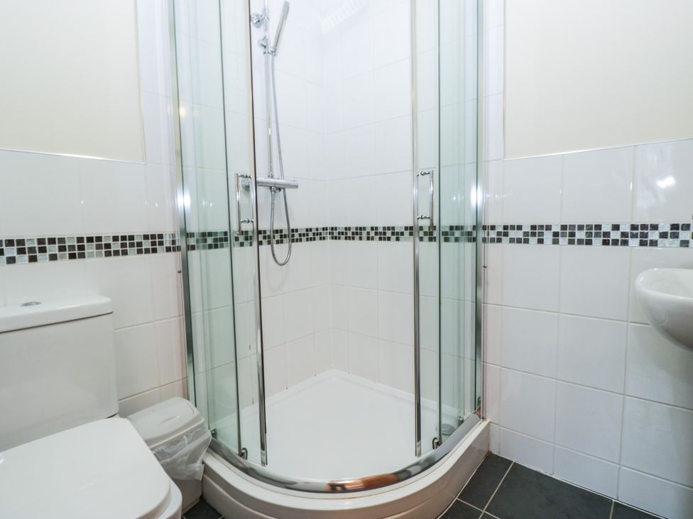 A bathroom with a shower, toilet, and sink at Birkbank Farm in Cockermouth