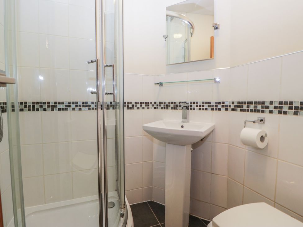 A bathroom with a shower, sink, and toilet at Birkbank Farm in Cockermouth