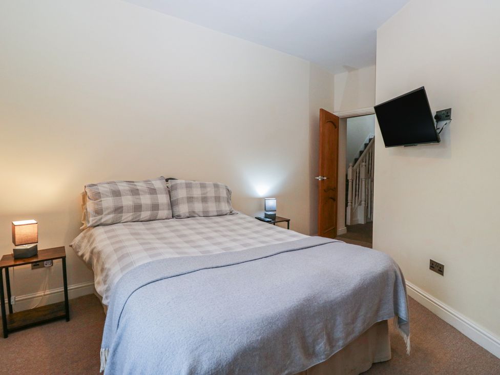 A bedroom with a bed and TV at Birkbank Farm in Cockermouth