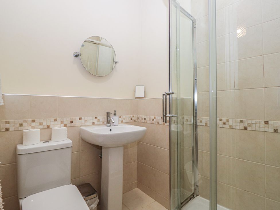 A bathroom with a shower, sink, and toilet at Birkbank Farm in Cockermouth