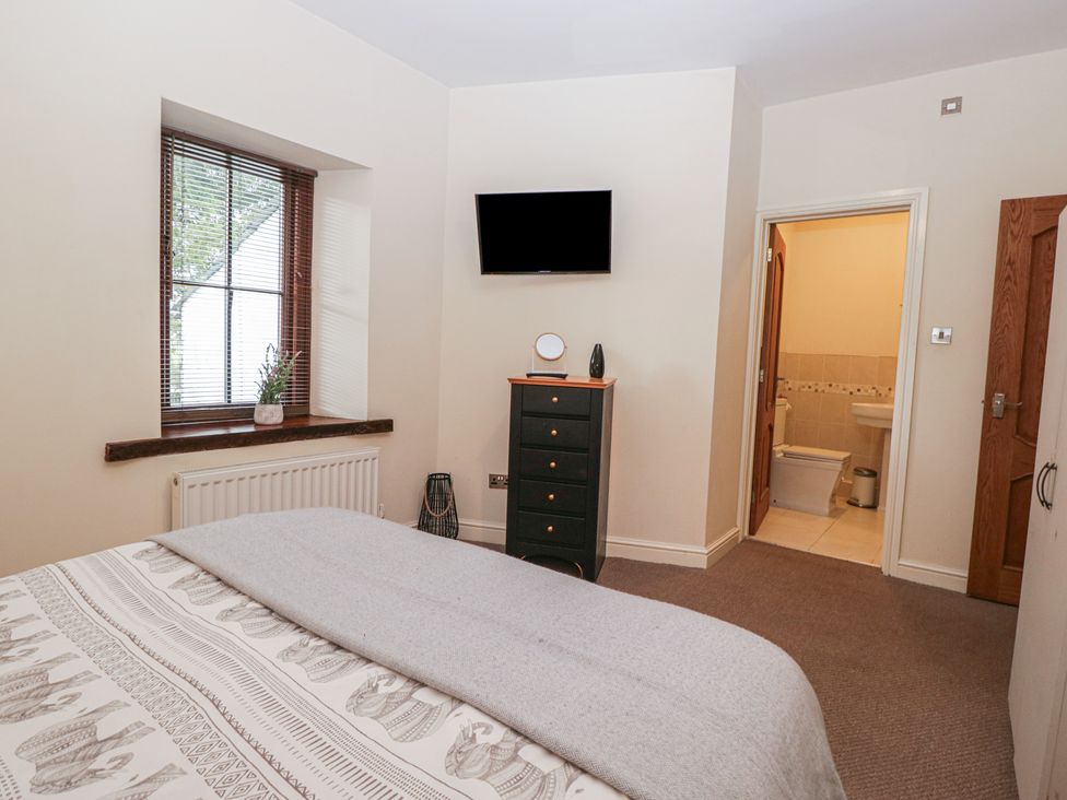 A bedroom with a bed and television at Birkbank Farm in Cockermouth