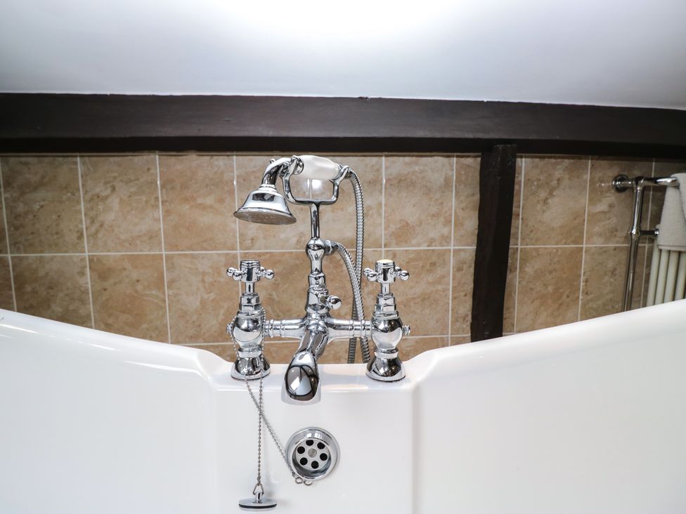 A bathtub with a chrome faucet and showerhead at Birkbank Farm in Cockermouth