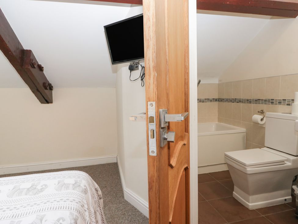 A bathroom with a bath tub and toilet at Birkbank Farm Cockermouth