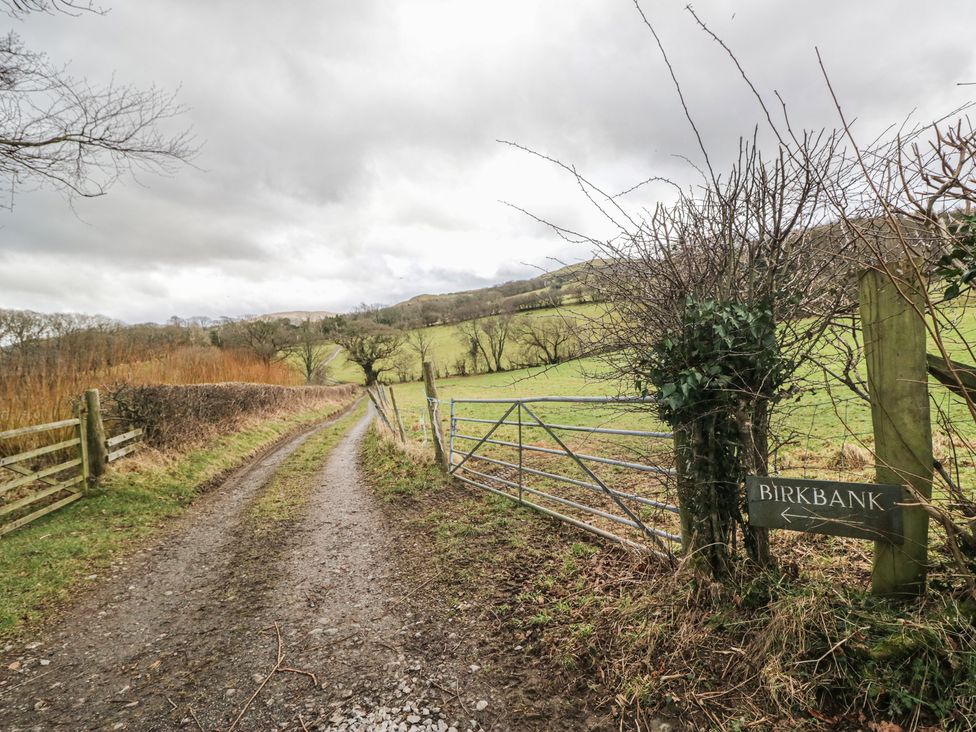 A pathway leading to Birkbank with a gate and sign in a rural area near Cockermouth