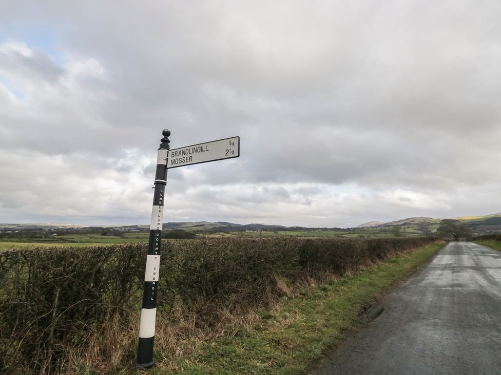 A signpost directing to Brandlingill and Mosser along a country road at Birkbank Farm Cockermouth
