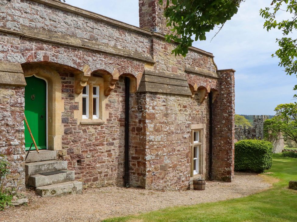 An exterior view of a stone building with a green door at Dowrich West Wing Apartment in Crediton