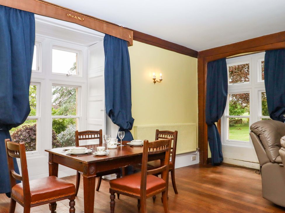 A dining room with a table and chairs at Dowrich West Wing Apartment in Crediton