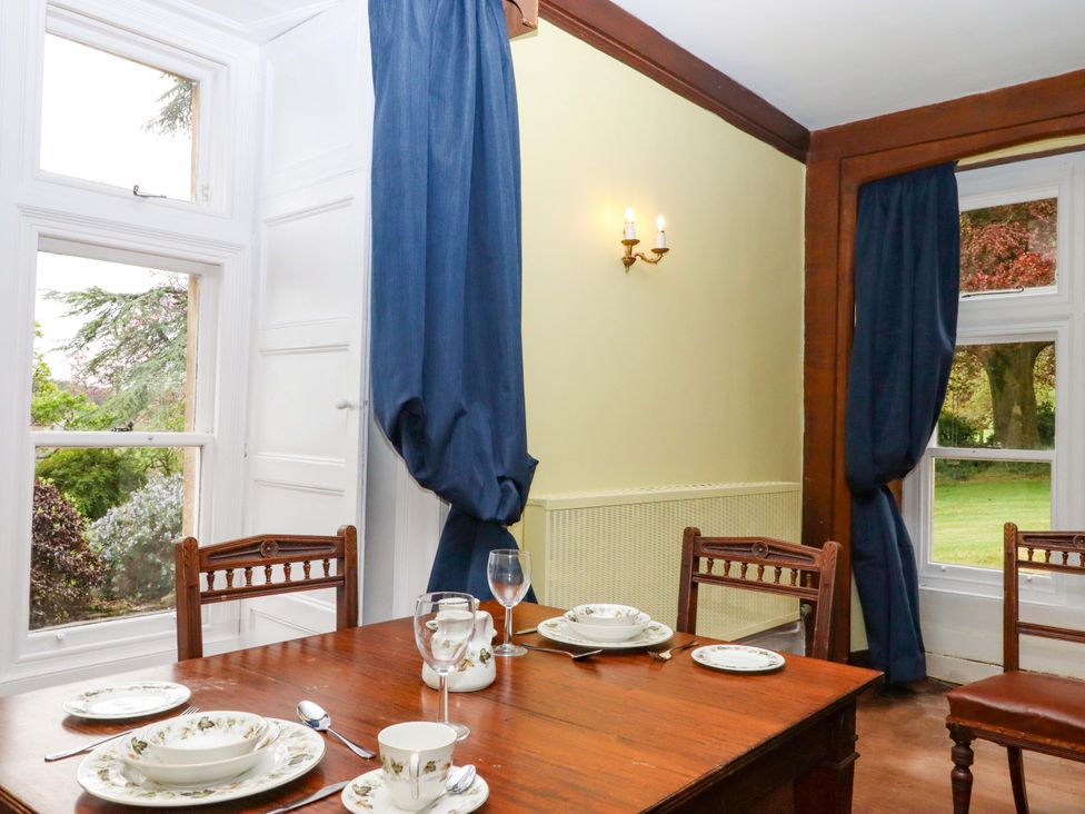 A dining room with a table set for meals at Dowrich West Wing Apartment in Crediton