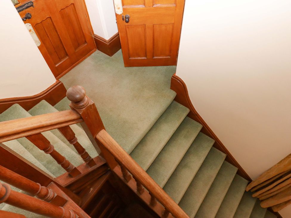 A staircase with wooden handrail and doors at Dowrich West Wing Apartment in Crediton