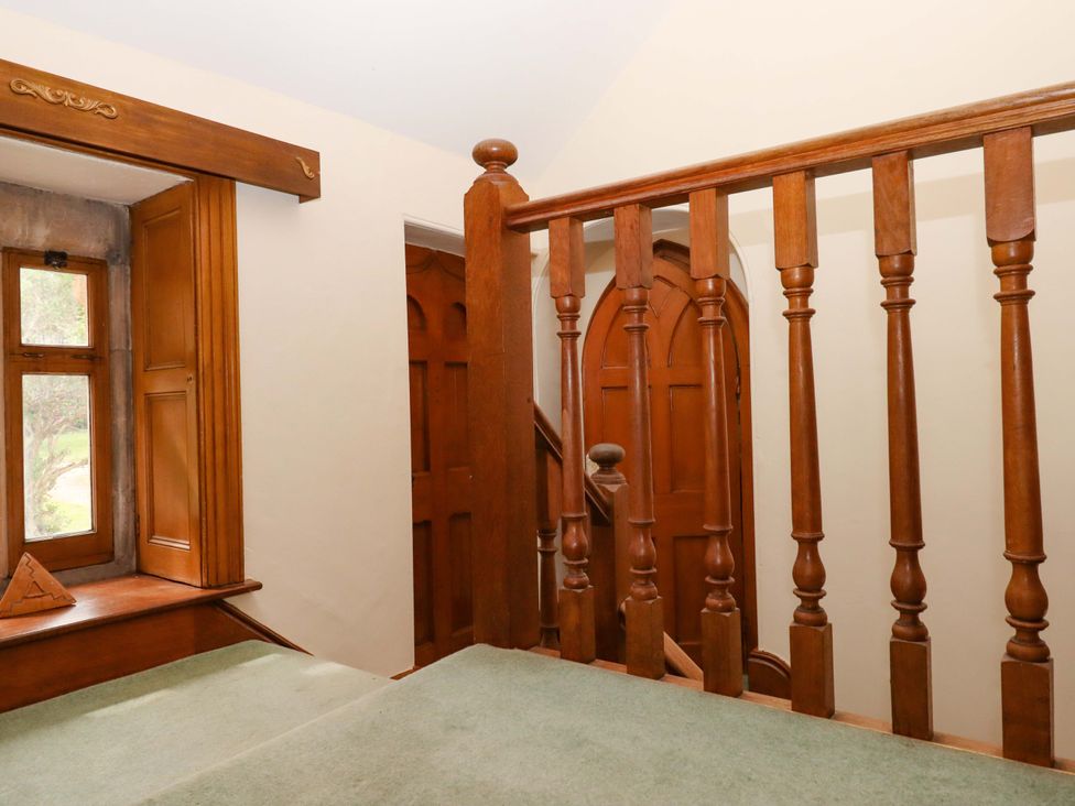A staircase with wooden railing and window at Dowrich West Wing Apartment in Crediton