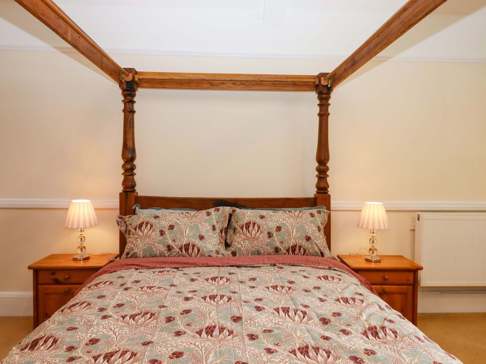A bedroom with a four-poster bed and bedside tables at Dowrich West Wing Apartment in Crediton