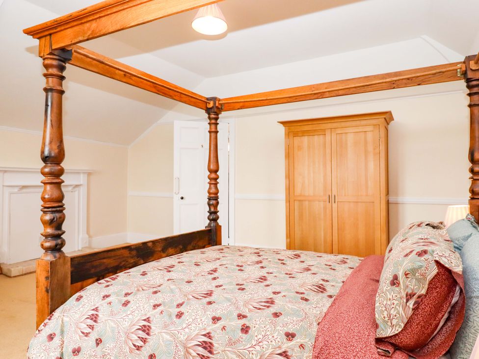 A bedroom with a four-poster bed and wardrobe at Dowrich West Wing Apartment in Crediton