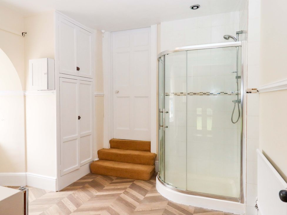 A bathroom with a shower and cupboards at Dowrich West Wing Apartment in Crediton