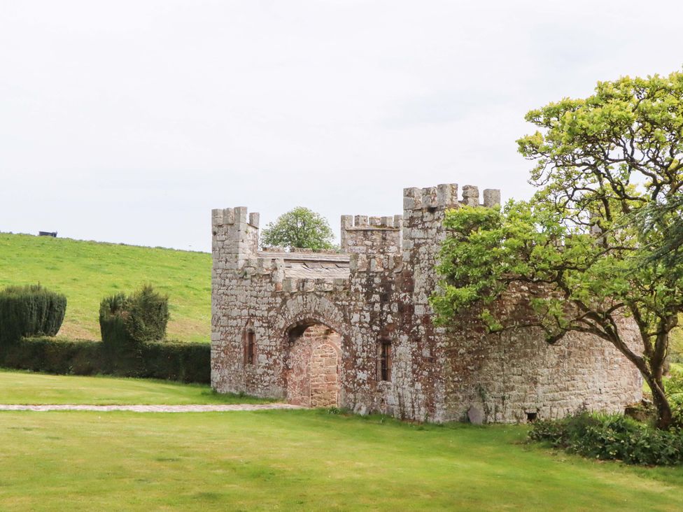 A stone castle structure in a grassy area at Dowrich West Wing Apartment in Crediton