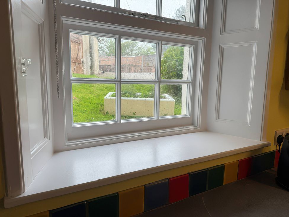 A kitchen window with a view of a grassy area at Dowrich West Wing Apartment near Sandford, Devon