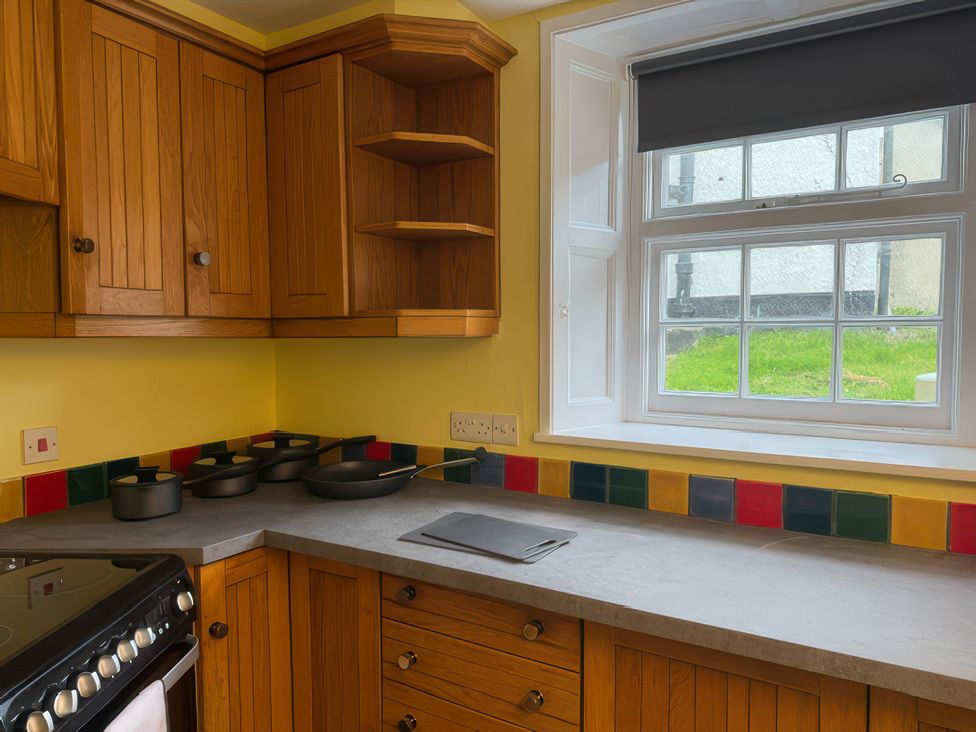 A kitchen with wood cabinets and cooking pots at Dowrich West Wing Apartment near Sandford, Devon