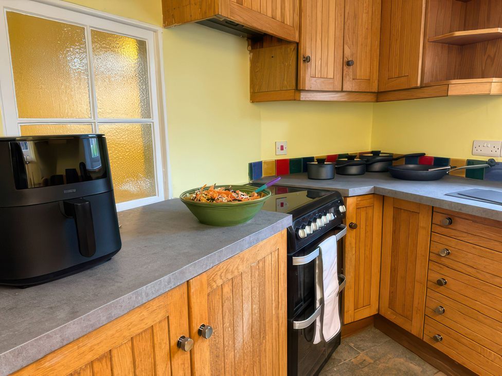 A kitchen with an air fryer and a bowl of salad at Dowrich West Wing Apartment near Sandford, Devon