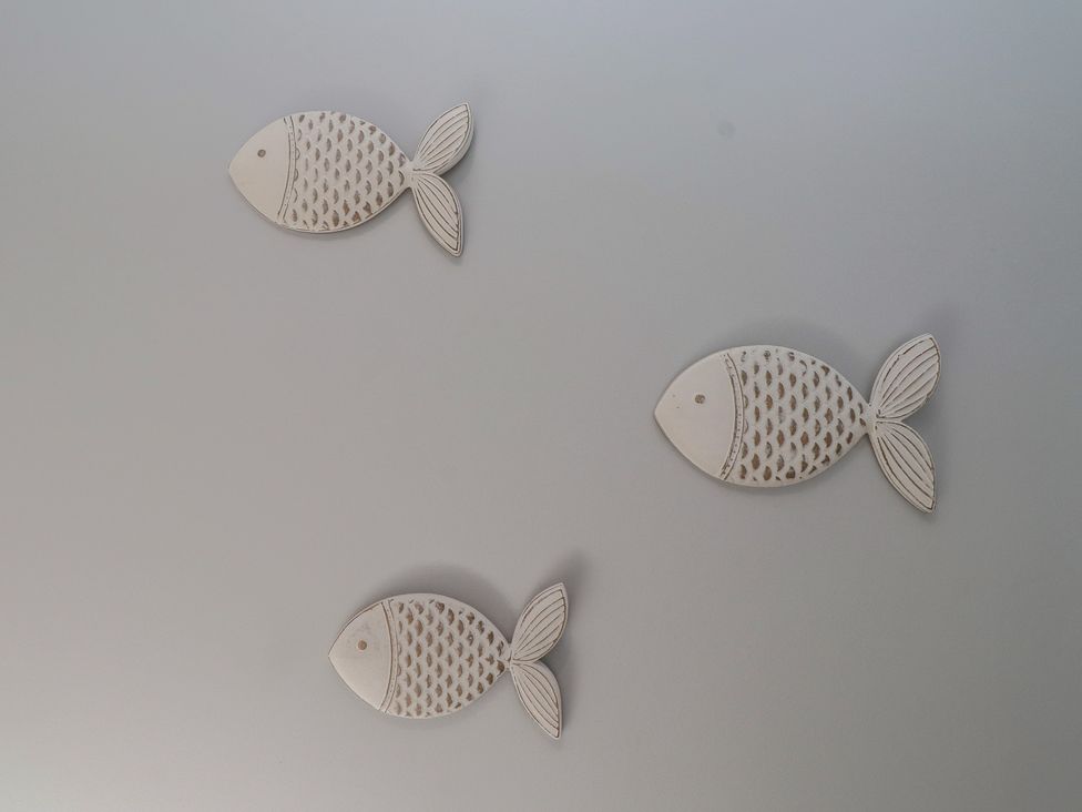 Decorative fish arrangement on a wall at Flat 1