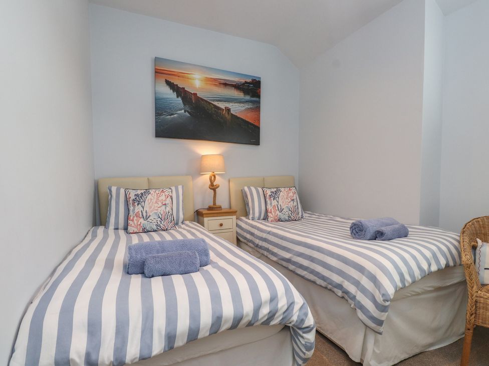 A bedroom with two single beds and a nightstand at Flat 1