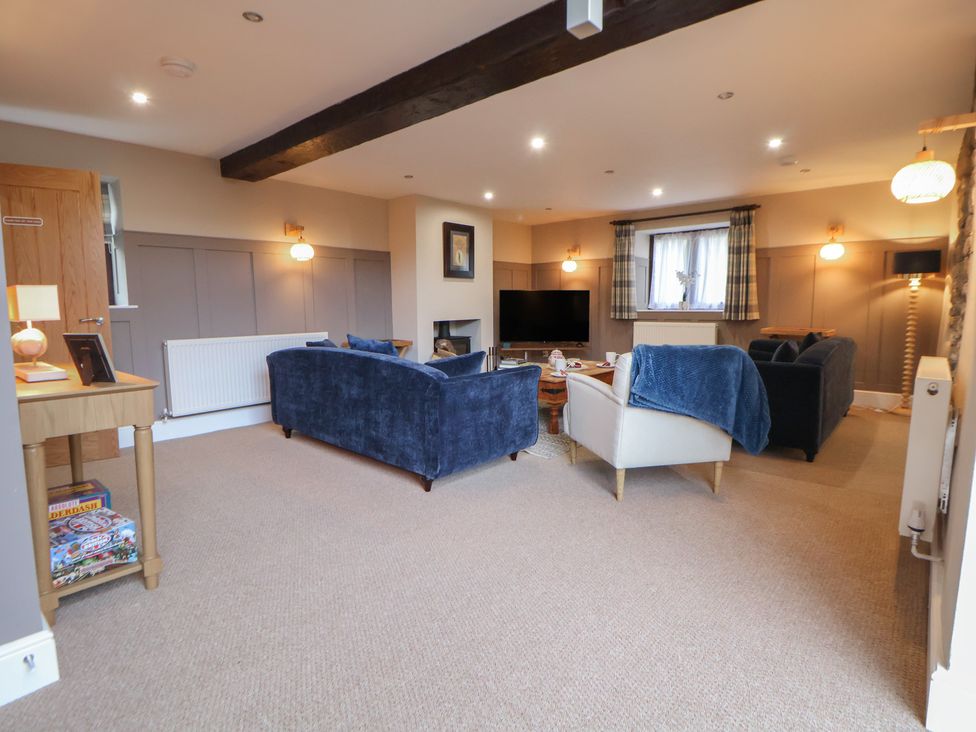 A living room with sofas and a television at The Forge in Castleton, Peak District