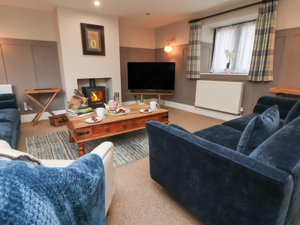 A living room with a fireplace and television at The Forge in Castleton, Peak District