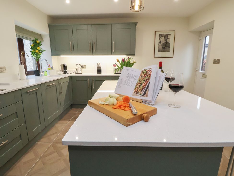 A kitchen with a cutting board and cooking book at The Forge in Castleton, Peak District