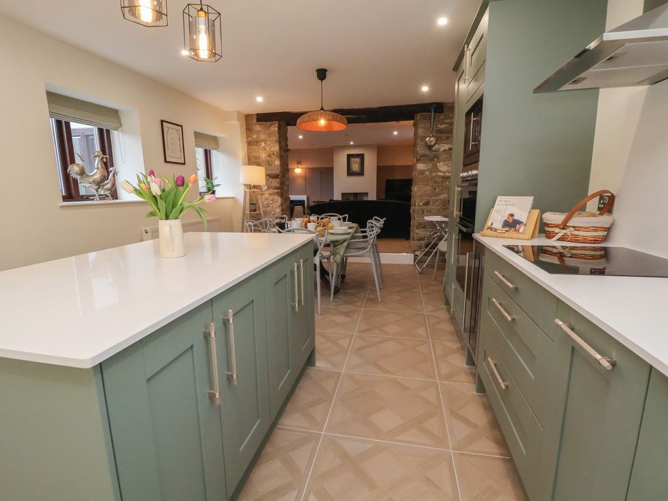 A kitchen with a central island and dining table at The Forge in Castleton, Peak District