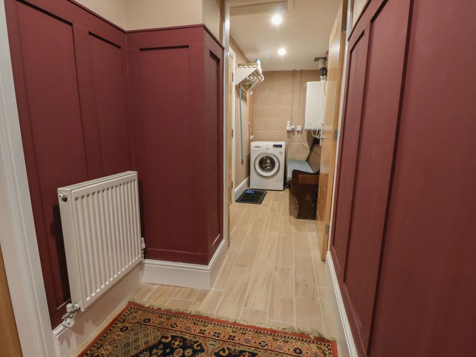 A laundry room with a washing machine and radiator at The Forge in Castleton, Peak District