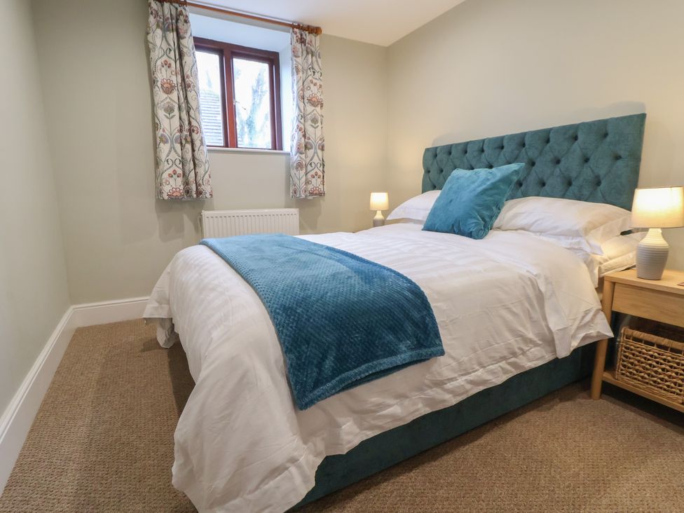 A bedroom with a bed and window at The Forge in Castleton, Peak District