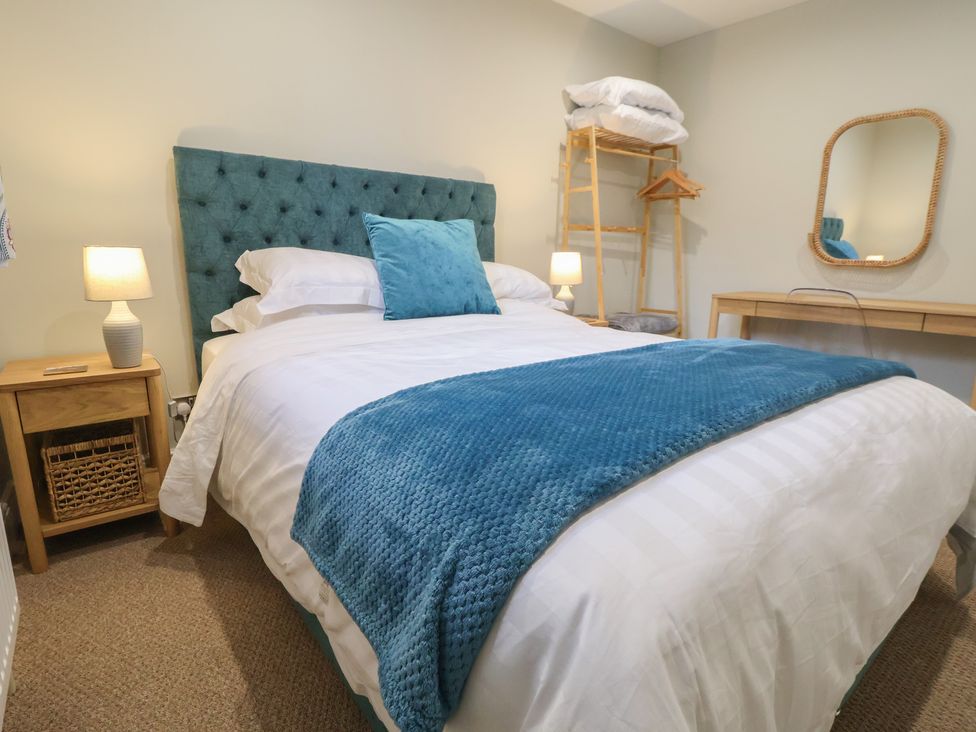 A bedroom with a bed, desk, and lamp at The Forge in Castleton, Peak District