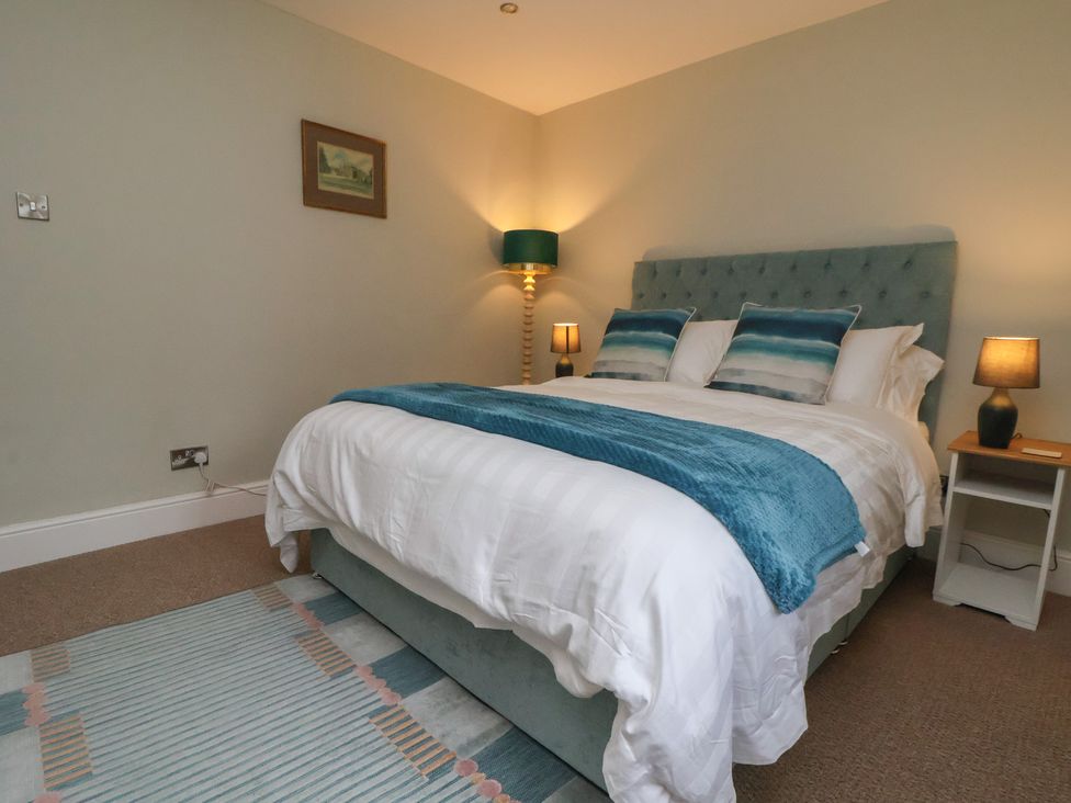 A bedroom featuring a bed, bedside tables, and lamps at The Forge, Castleton, Peak District