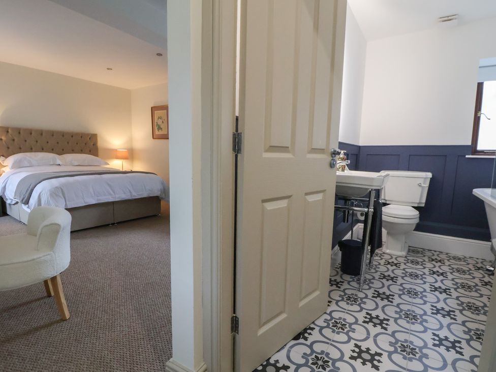 A bedroom with a bed and a bathroom visible at The Forge in Castleton, Peak District