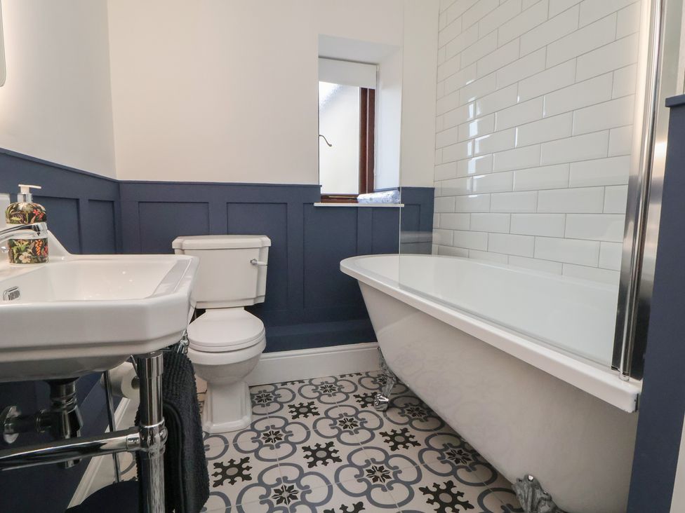 A bathroom with a bathtub, toilet, and sink at The Forge in Castleton, Peak District