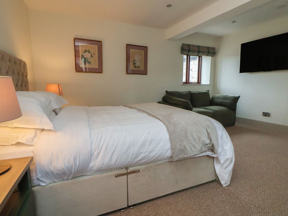 A bedroom with a bed and sofa at The Forge in Castleton, Peak District