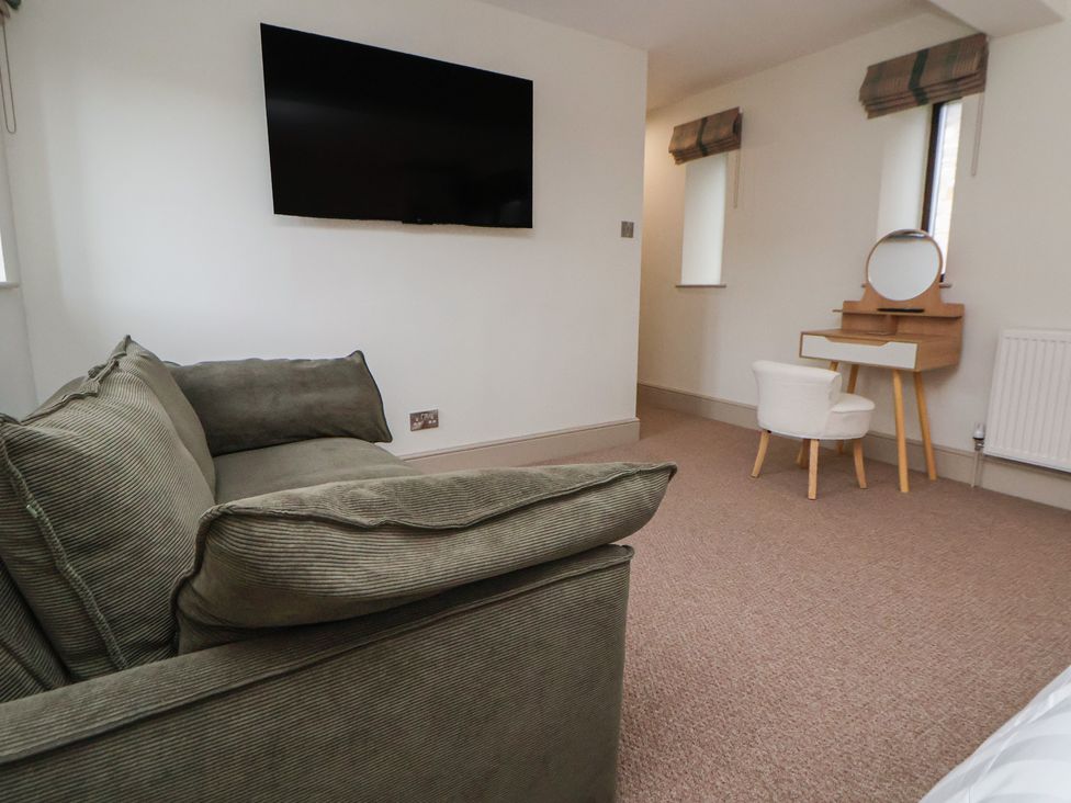 A living room with a sofa and television at The Forge in Castleton, Peak District