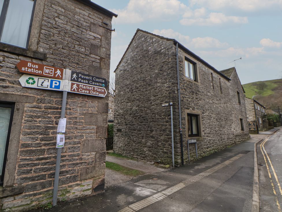 An outdoor area with signs and stone buildings at The Forge in Castleton, Peak District