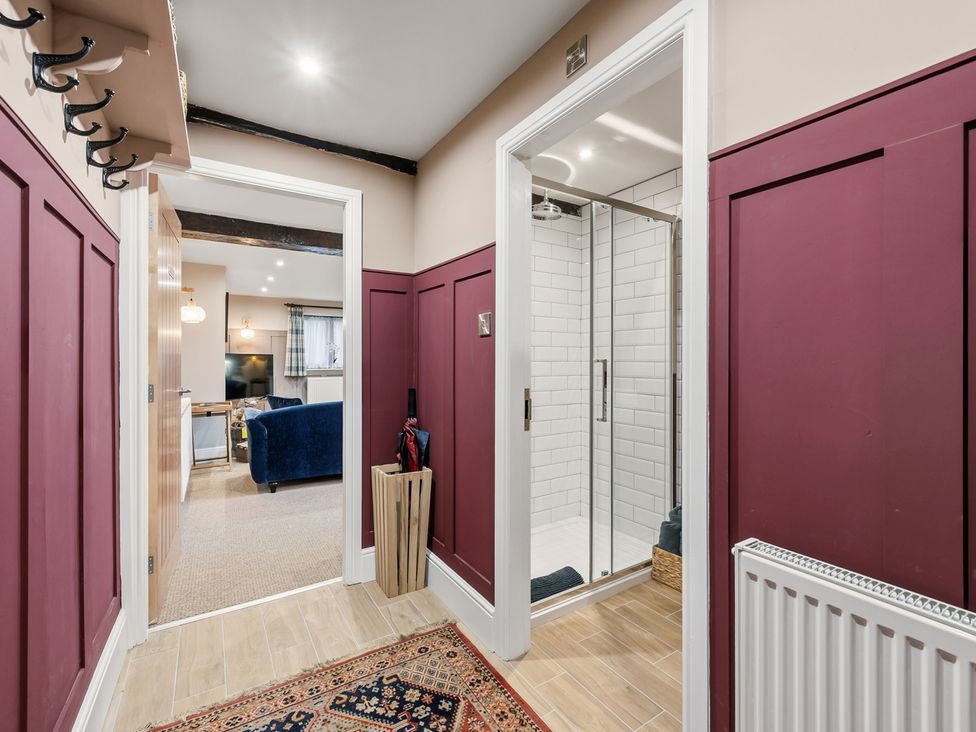 A hallway with a shower stall and coat hooks at The Forge in Castleton, Peak District