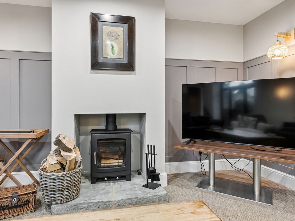 A living room with a fireplace and TV at The Forge in Castleton, Peak District