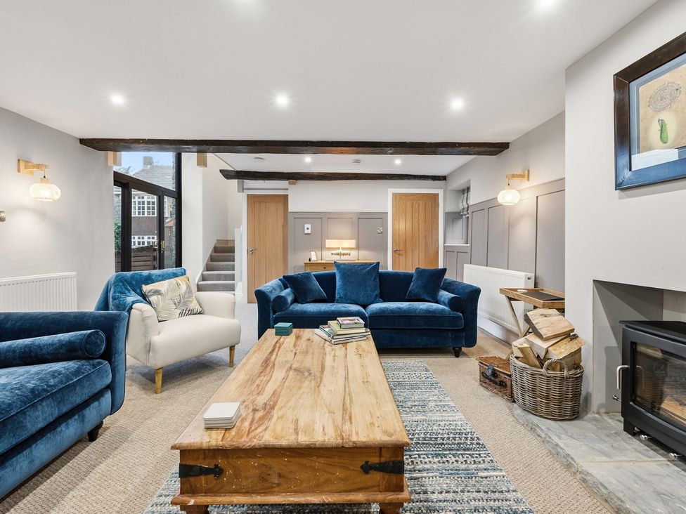 A living room with a coffee table and blue sofas at The Forge in Castleton, Peak District